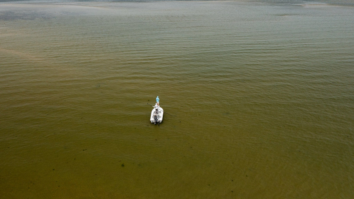 Two individuals flats fishing off a boat